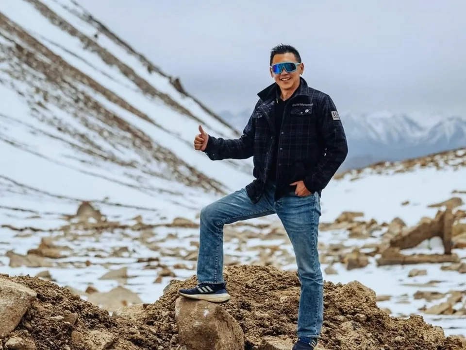 KK Wong giving a thumbs up on a snowy mountain slope