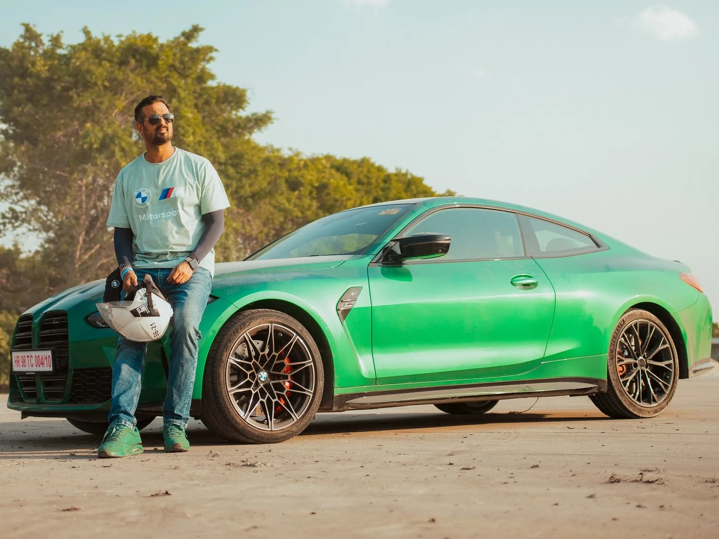 Vieekas Tanwar standing by a green BMW, a helmet in his hand